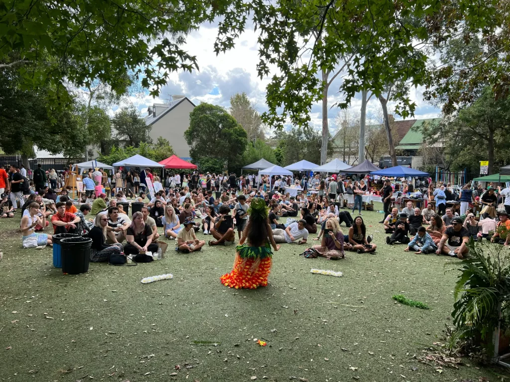 woman sitting on grass surrounded by crowd of people